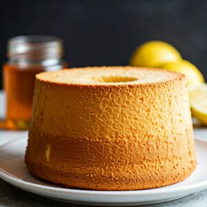 picture of lemon cake with honey cooked in tube pan with lemons and honey jar in the background